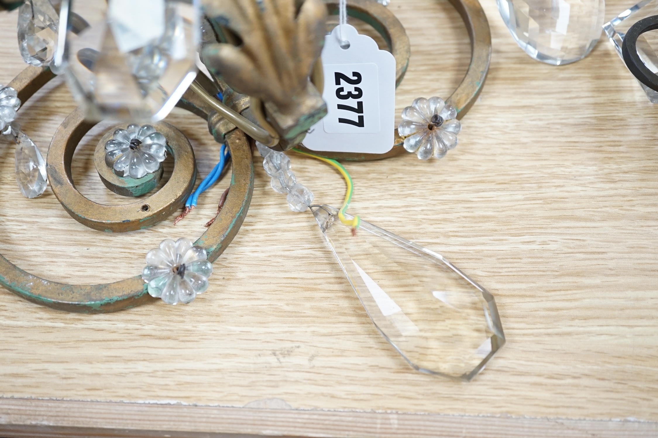 A pair of two branch gilt painted metal wall lights with lustre drops, approximately 44cm high. Condition - fair to good